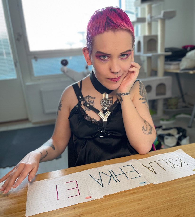 Pinja istuu pöydän ääressä, edessään laput joissa lukee KYLLÄ, EHKÄ ja EI.