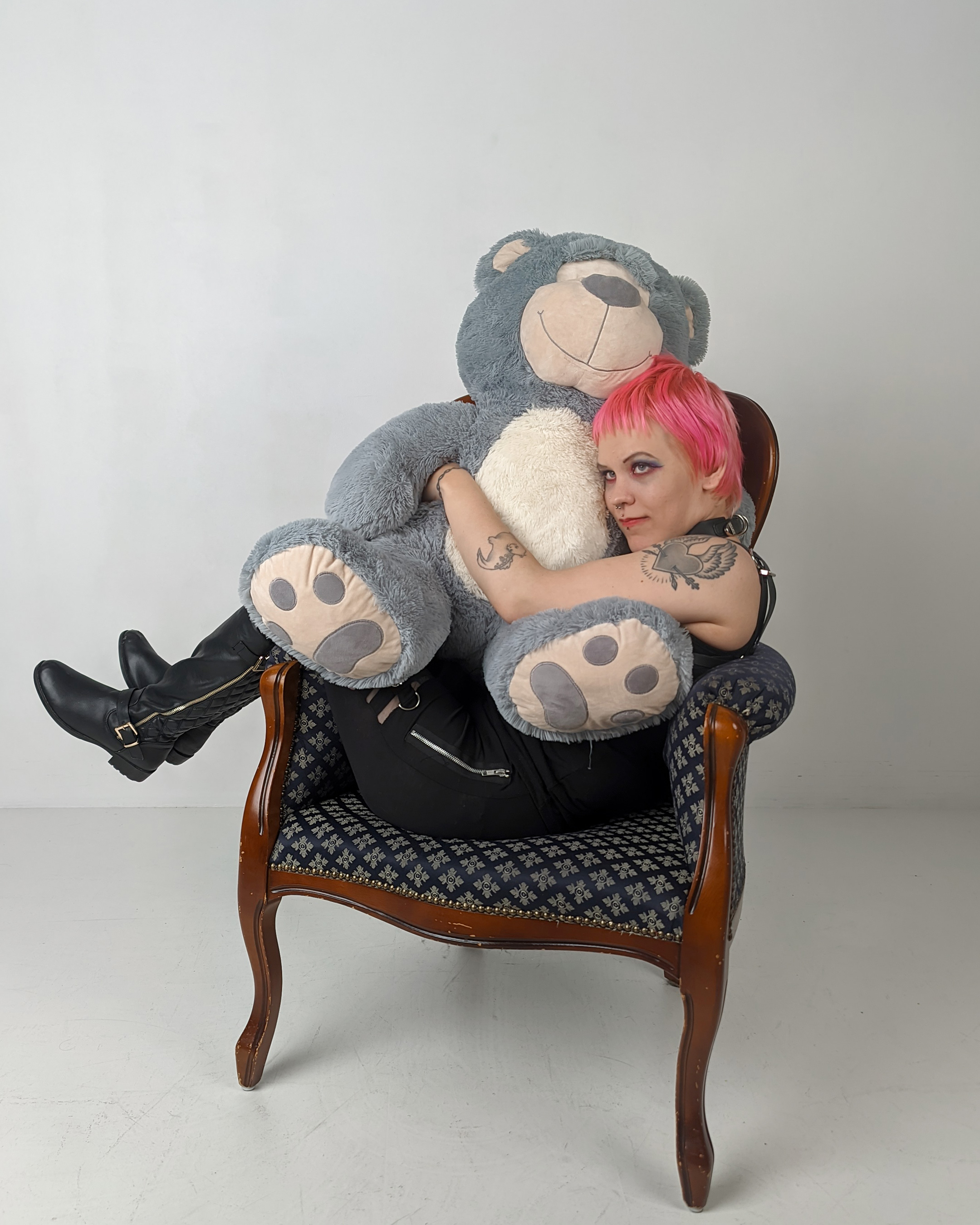 Pinja istuu nojatuolissa ja halaa jättikokoista pehmonallea hymyillyen