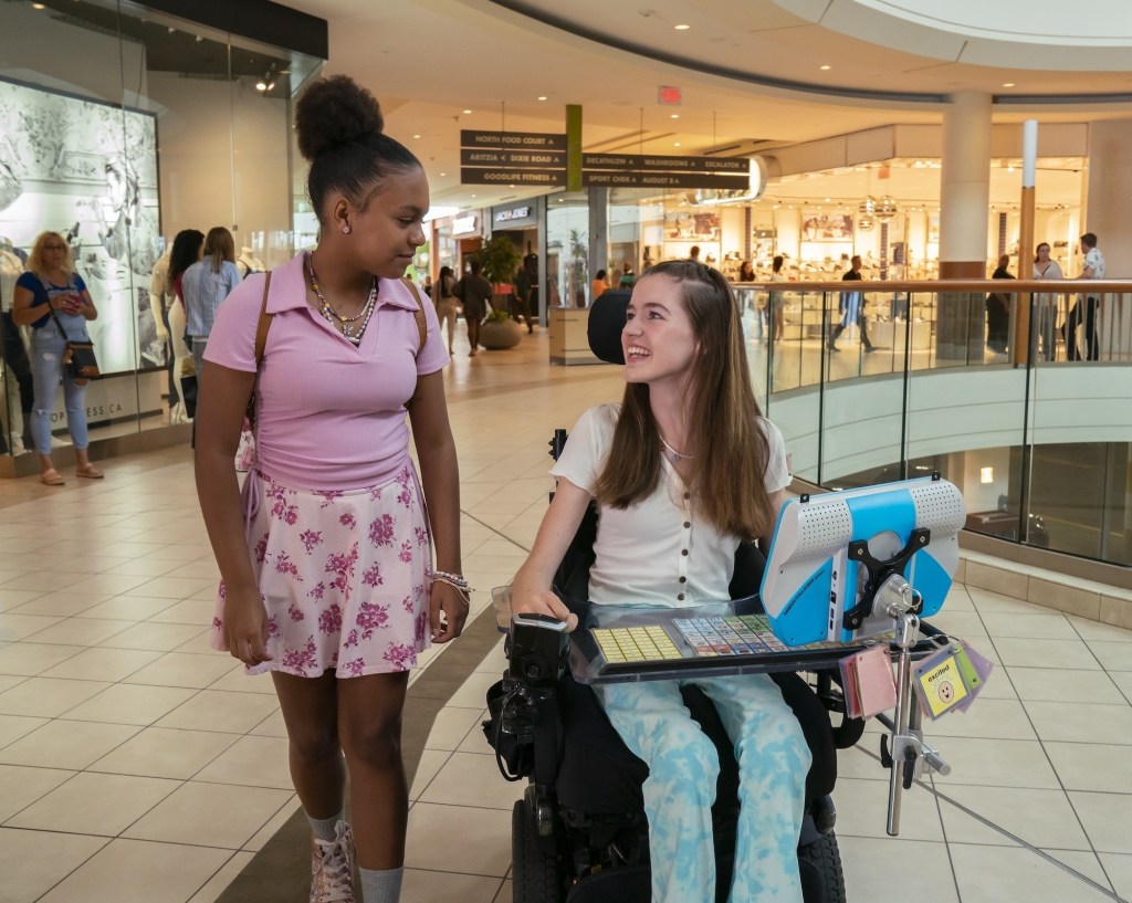 Melody ja hänen ystävänsä Rose katselevat toisiaan kulkiessaan ostoskeskuksessa.