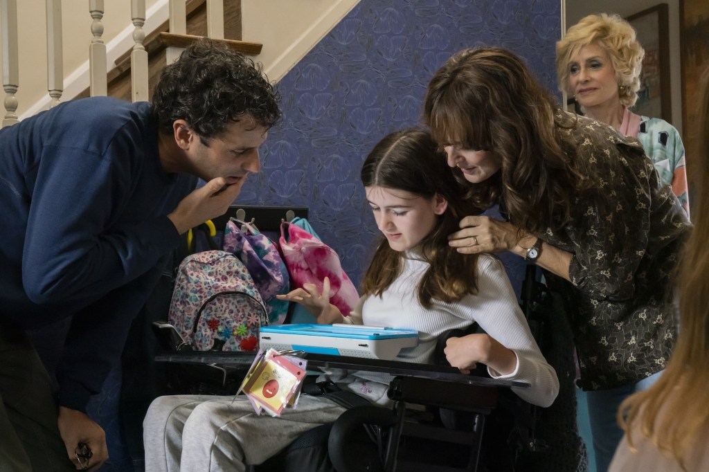 Melody istuu pyörätuoliss aja käyttää ensimmäistä kertaa Meditalker-kommunikaatiolaitetta. Hänen äitinsä, isänsä ja naapurin rouva ovat kokoontuneet hänen ympärilleen. Kuvan tunnelma on iloinen ja utelias.