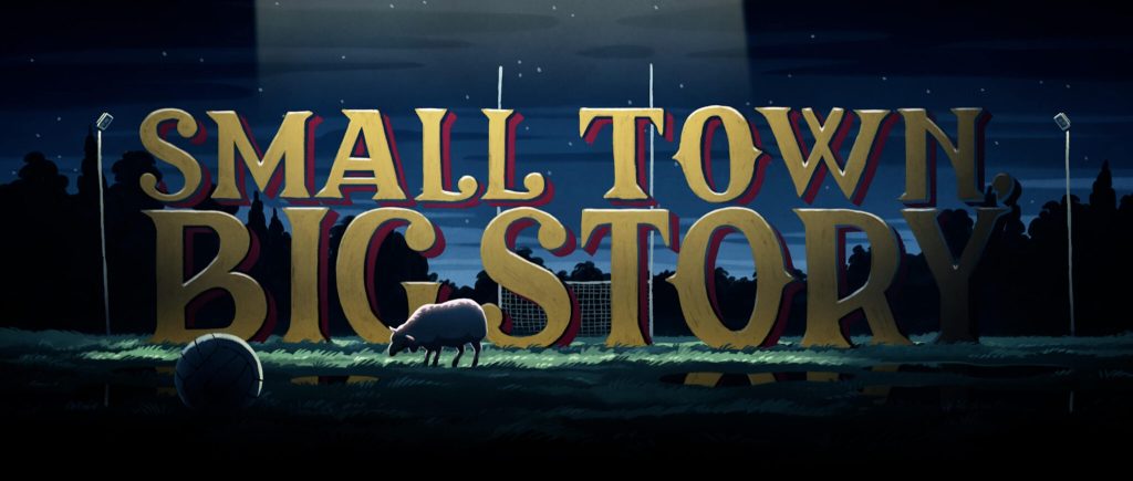 Small Toen, Big Story -sarjan logo. Animoidussa kuvassa sarjan nimi seisoo isoilla ystävällisen näköisillä kirjaimilla keskellä jalkapallokenttään. Logoon osuu ylhäältä ufon valokeila, joka valaisee myös logon edessä laiduntavan lampaan.